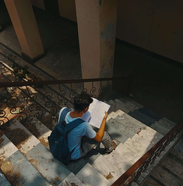 Photo by Srijit Mudi of a student reading on stairs